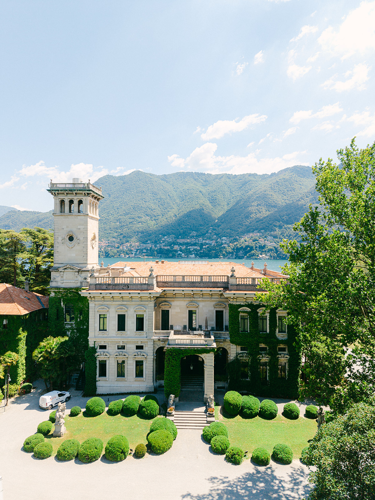Aerial view of Villa Erba's facade and landscaped gardens beside Lake Como.