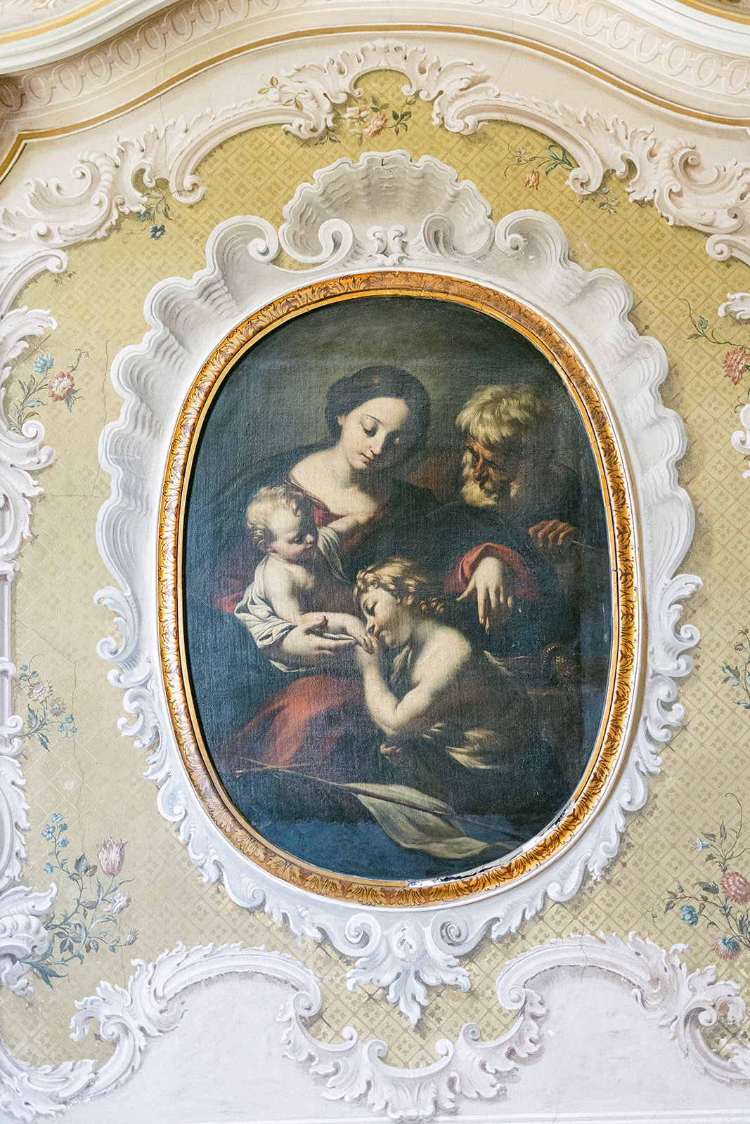 Decorative framed painting on an ornate interior wall at Villa Erba.