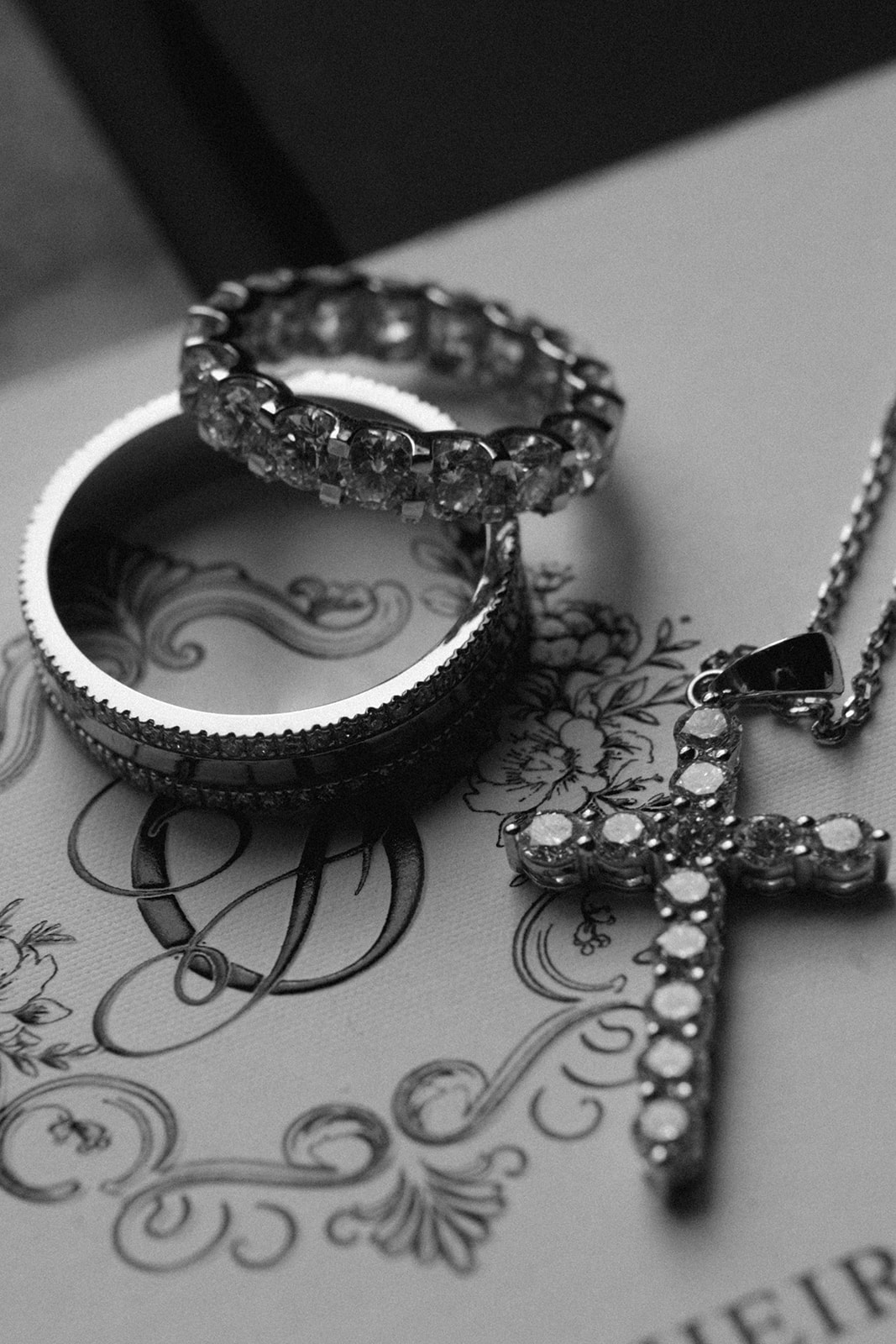 Black and white detail of bridal bracelets and earrings on an illustrated invitation.