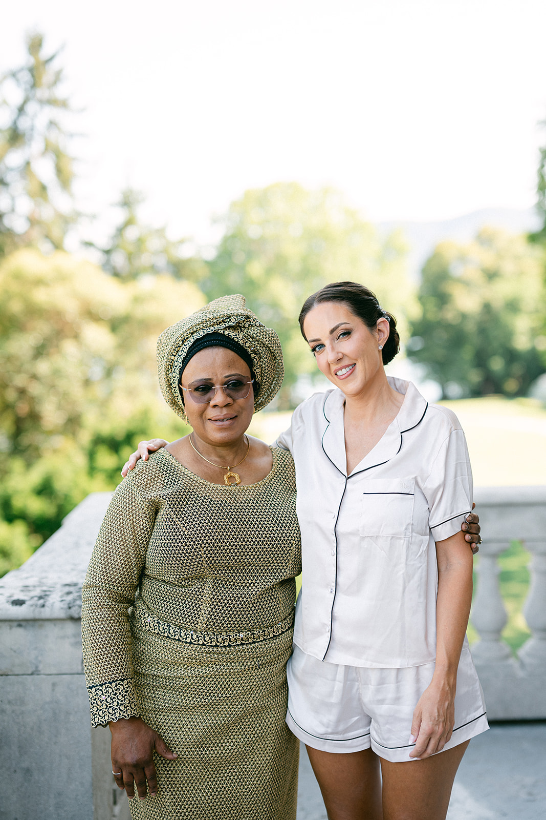 Two women posing together in the gardens during Fran and Ope's wedding preparations.