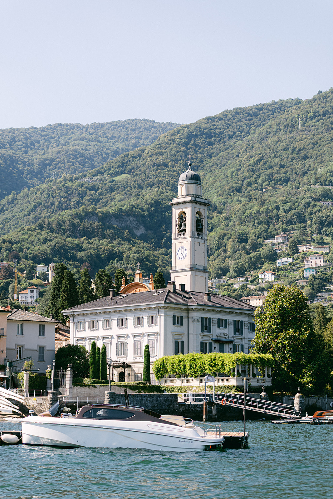 Villa Erba's lakeside facade with a white motorboat on Lake Como.