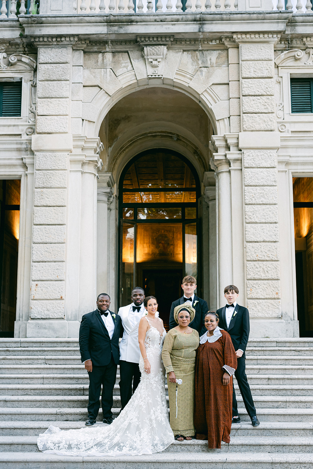 Fran and Ope posing with loved ones on the entrance steps of Villa Erba.